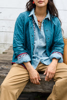 The jacket is shown with its print fabric worn on the interior. The exterior is solid teal fabric. Pop of the navy and white print adorn the jacket's cuffs.