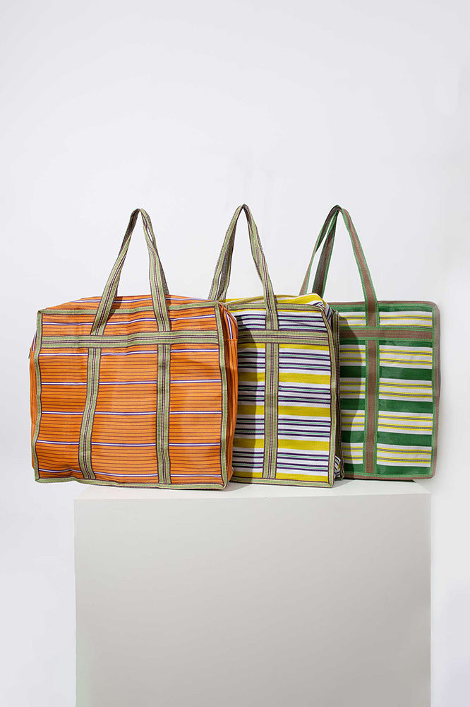    	 Three of the XL Market Totes are shown grouped together. Each is made of upcycled nylon fabric with a stripe pattern, but each is a different color. One is green and orange, one is blue and yellow, and one is green and yellow.