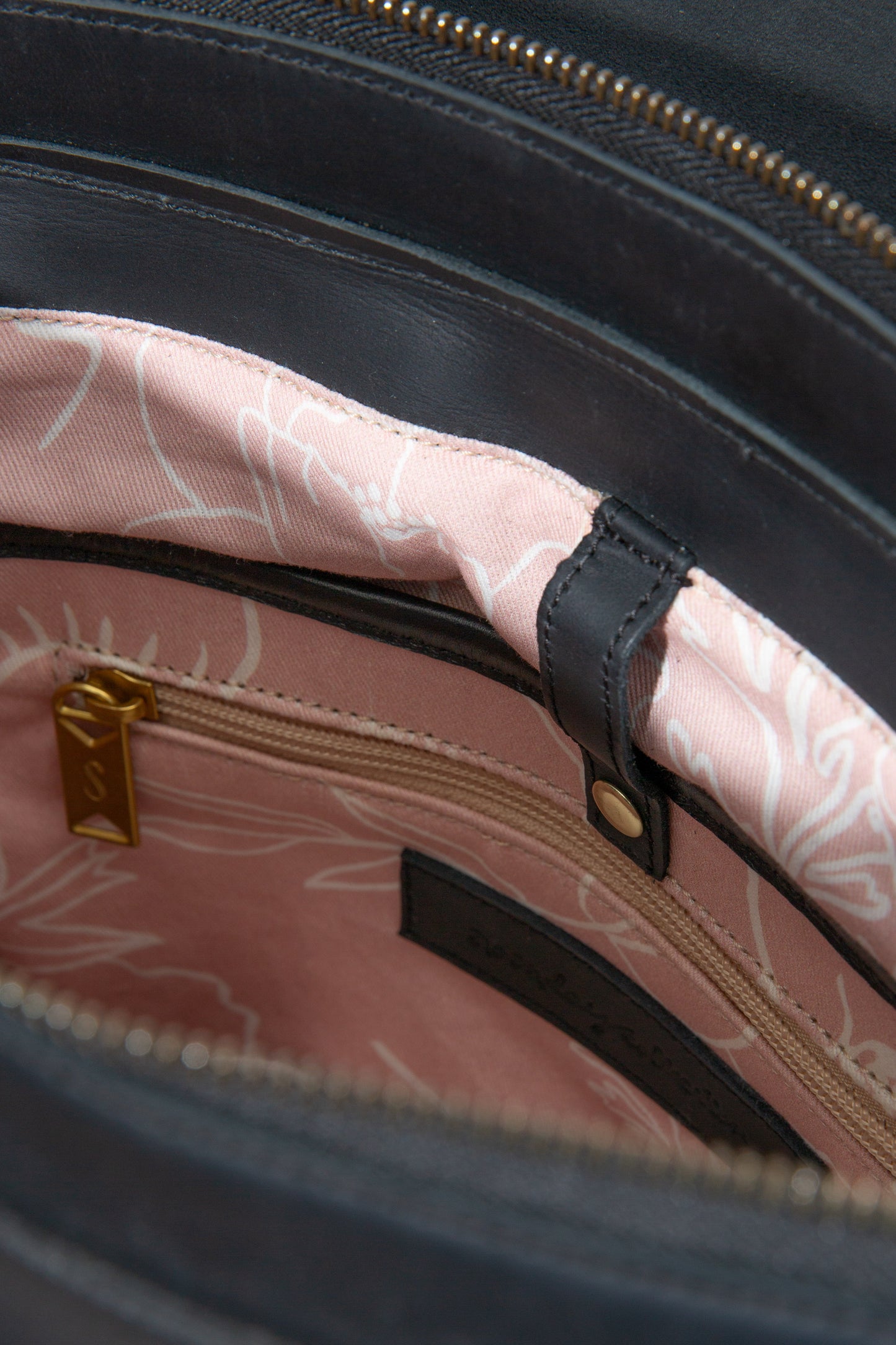 The interior front wall of the Debut Backpack is shown. There are two fabric pockets stitched into the wall of the bag.