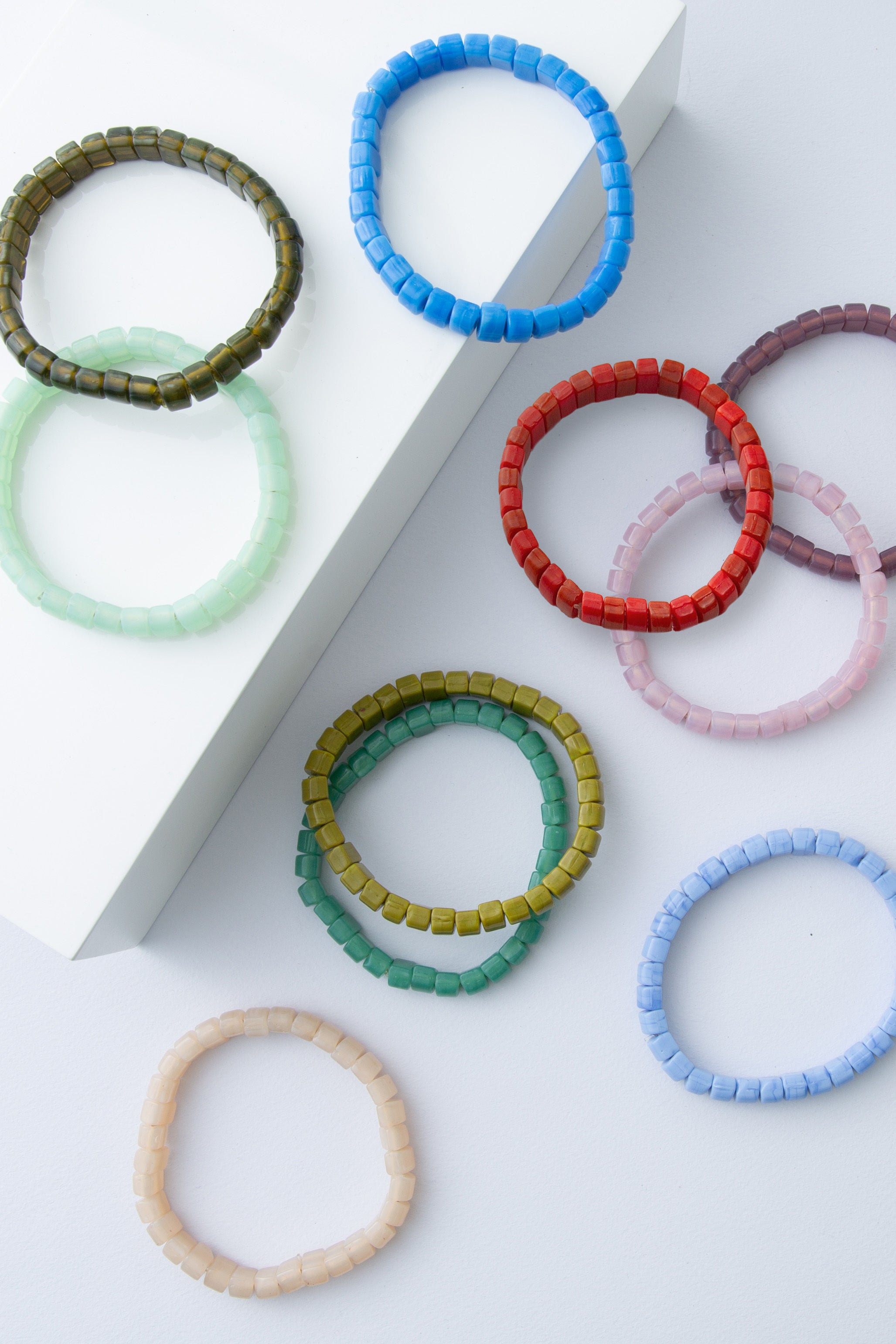 Colorful beaded bracelets on a white surface