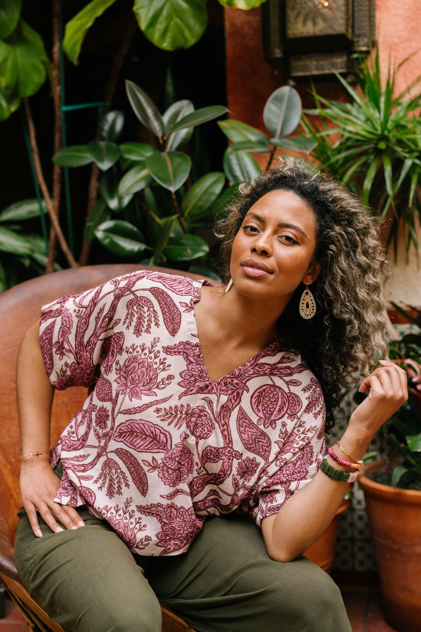 The Oversized Boxy Top is a flowy short sleeve blouse. The fabric is a soft blush color with printed pink florals. The top has a square shaped silhouette and a v neck. 