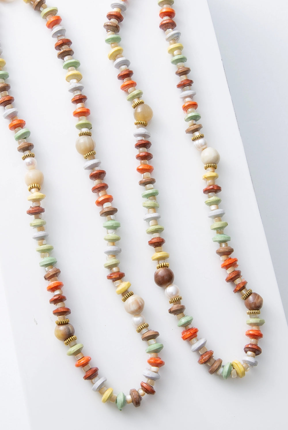 Two Pamoja Necklaces are shown side by side, demonstrating the variation in shade and texture that can occur due to the natural materials utilized.