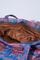 The interior of the Quilted Cotswold Tote is shown. The bag has a silky brown lining. Two interior fabric pockets are stitched into the wall of the bag.