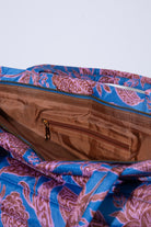 The interior of the Quilted Cotswold Tote is shown. The bag has a silky brown lining. One interior zipper pocket is stitched into the wall of the bag.