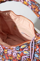 The interior of the Quilted Zipper Tote is shown. It has a tan fabric lining. There is a zipper pocket stitched into the back wall of the interior.