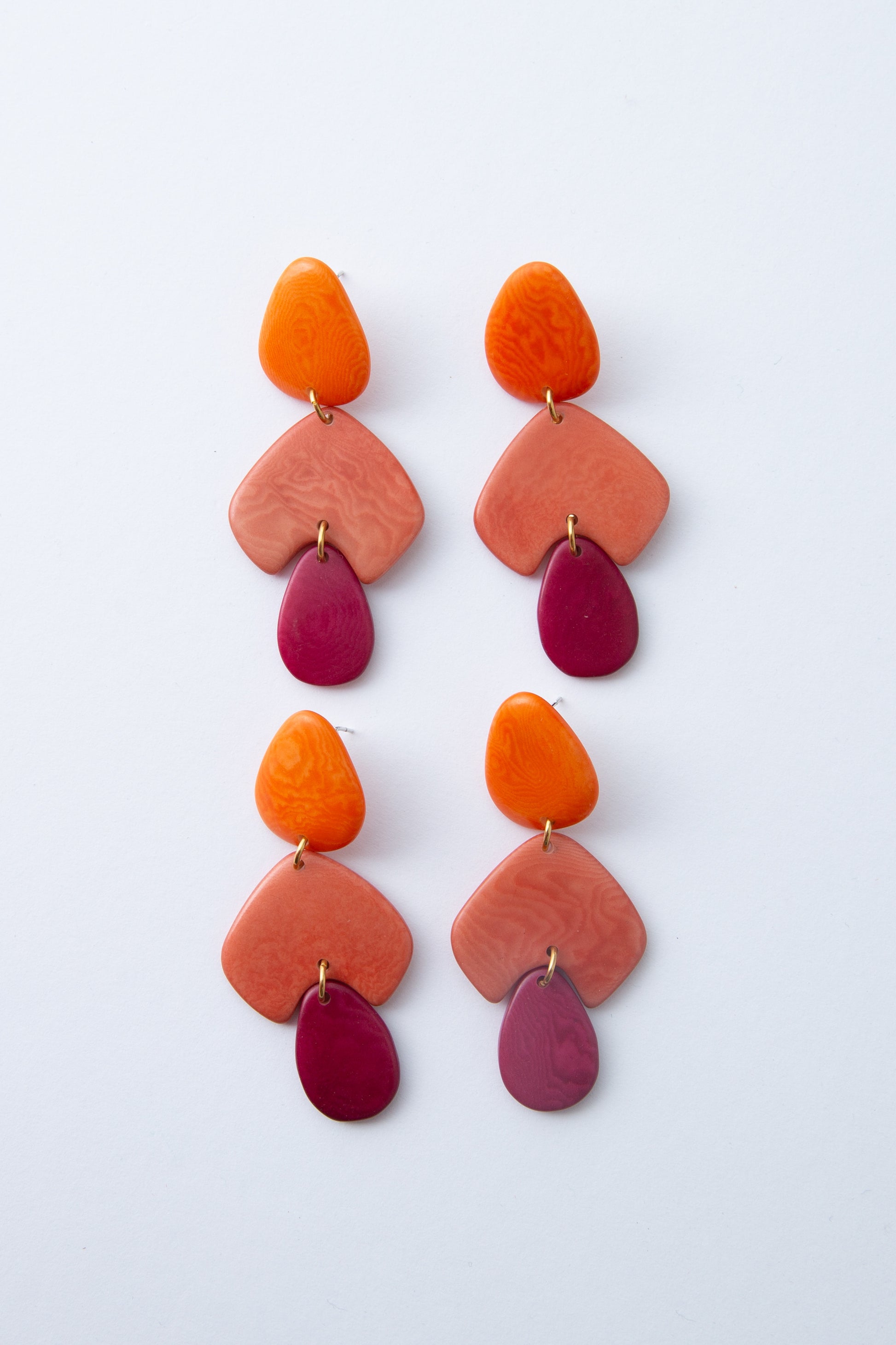 Two pairs of Sorbet Sunset Earrings are shown to highlight the color variations that can occur. The tagua pieces can be either lighter or darker due to the natural material used.