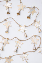 This is a rustic style rope garland with flat, metallic stars attached at regular intervals. The stars are silver and gold metal with a weathered look. There is a metallic cone-shaped bell attached to each star.