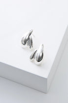 Pair of silver earrings on a white surface