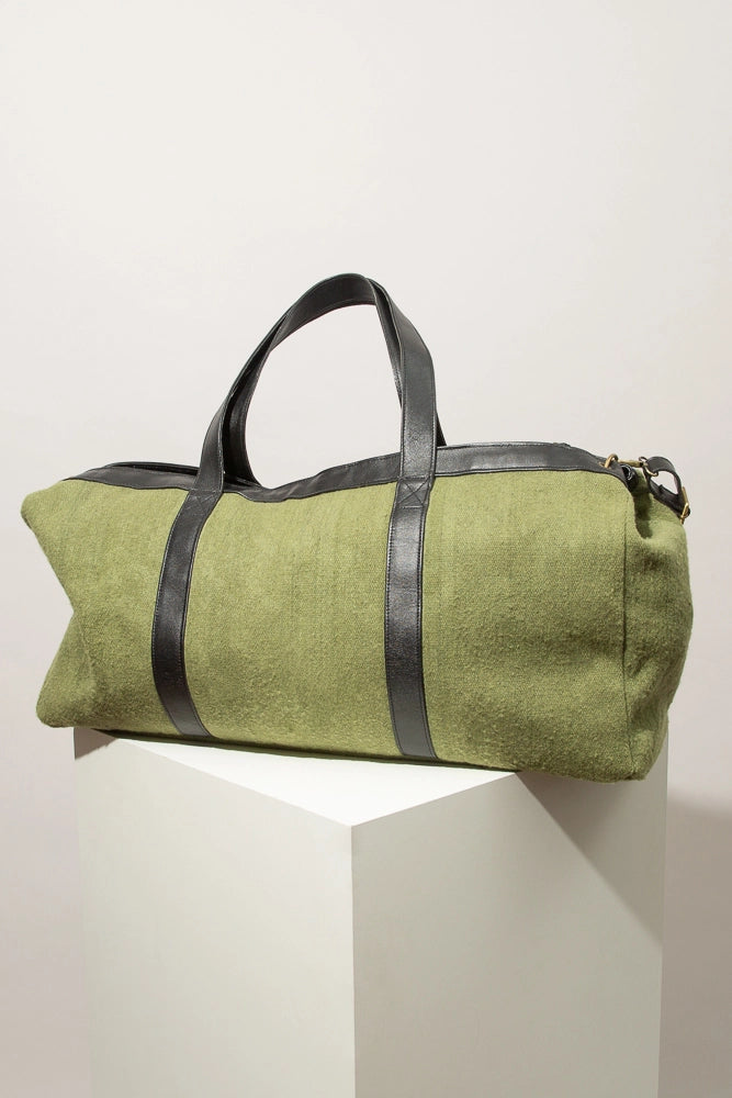 The back of the Flourish Weekender is pictured. It is composed of the same light green wool as the front, but with no embroidered accents.