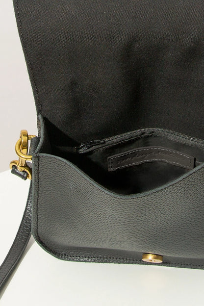 The flap of the Go-Getter Bag is open, revealing the interior. The bag has a black fabric lining and there is a zipper pocket stitched into the interior back wall.