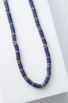 This is a single-strand necklace composed of hundreds of cobalt blue disc-shaped beads. Every inch or so, there are shining gold disc beads strung between the blue beads. 