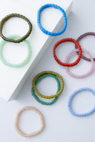 Colorful beaded bracelets on a white surface