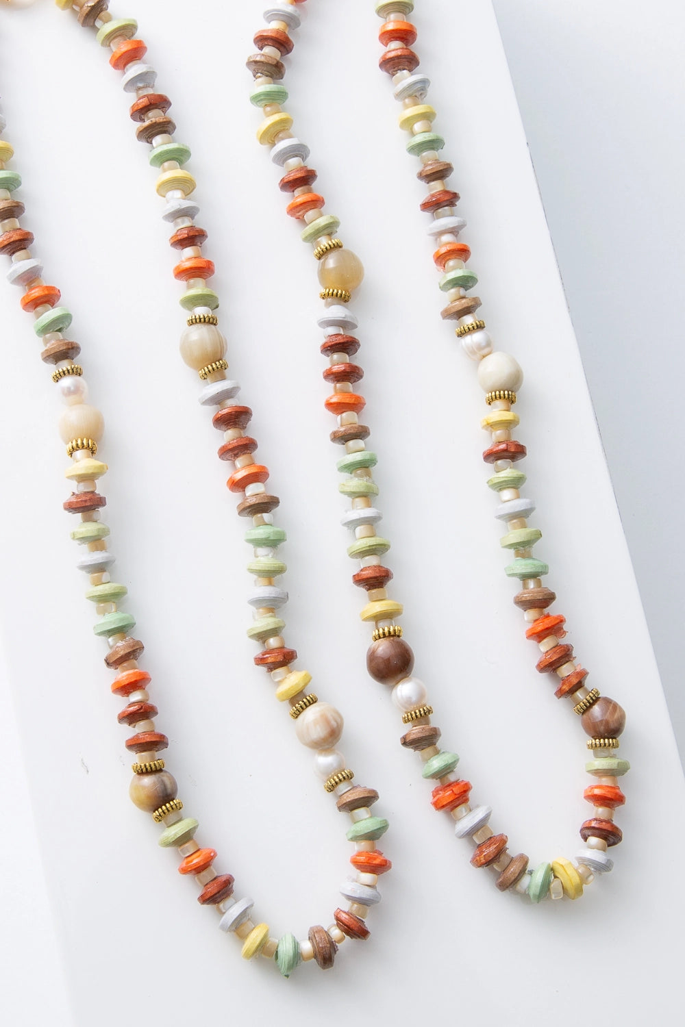 Two Pamoja Necklaces are shown side by side, demonstrating the variation in shade and texture that can occur due to the natural materials utilized.