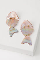 The Shellfish Earrings are composed of iridescent pink shell with natural purple and green striations. Three flat pieces of shell are linked together with gold jump rings to create a fish silhouette that can move freely.
