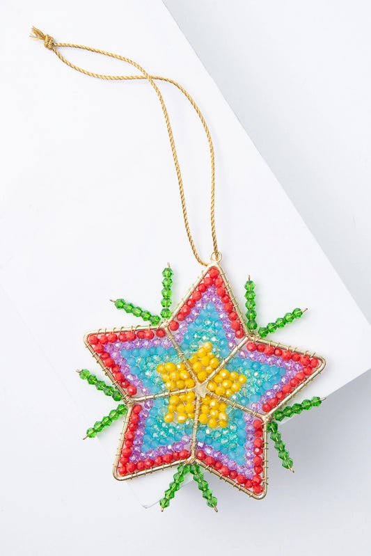 The Starbright Ornament is a flat beaded ornament in the shape of a five-pointed star. The outline of the star is gold metal and the interior is composed of many tiny glass beads in shades of yellow, blue, purple, and red. Lines of green glass beads emanate out from the sides of the ornament, giving it the look of a shining star.